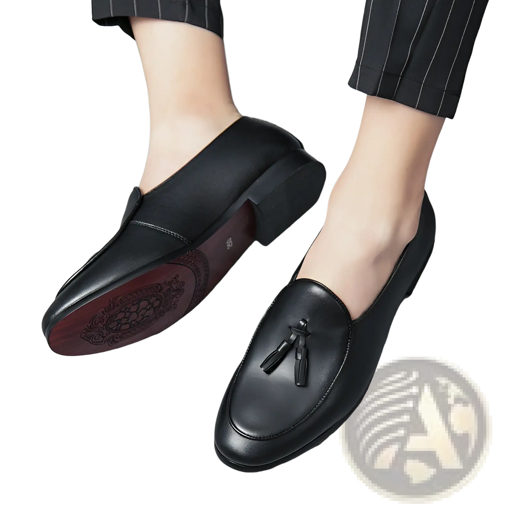 Black leather British tassel loafers for young men with decorative sole pattern and tassel detail