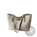 Cream-colored shearling tote bag with tan leather straps and gold-tone hardware in brown faux fur style