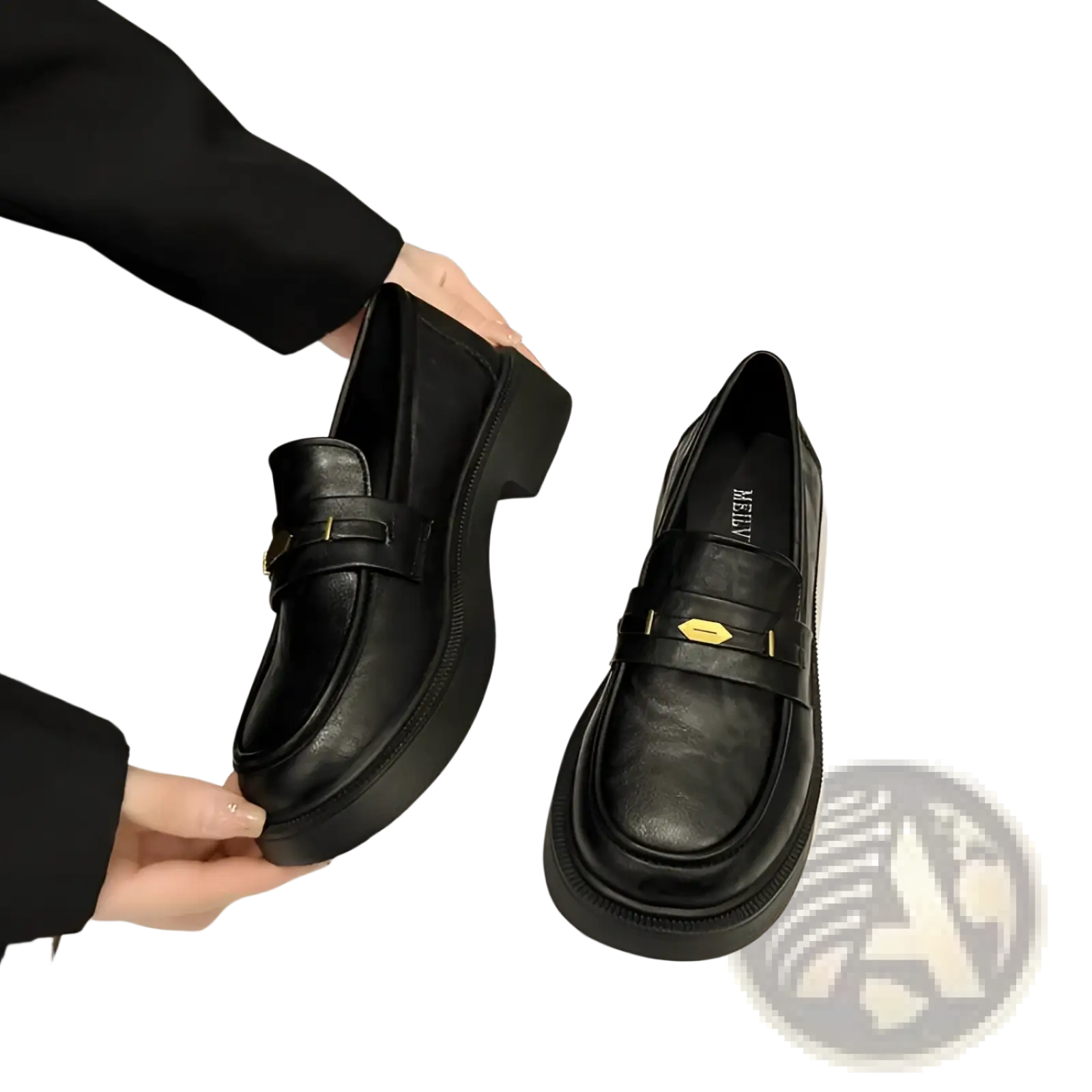 Black leather loafers with chunky sole and gold-tone buckle detail creating a bold and stylish look