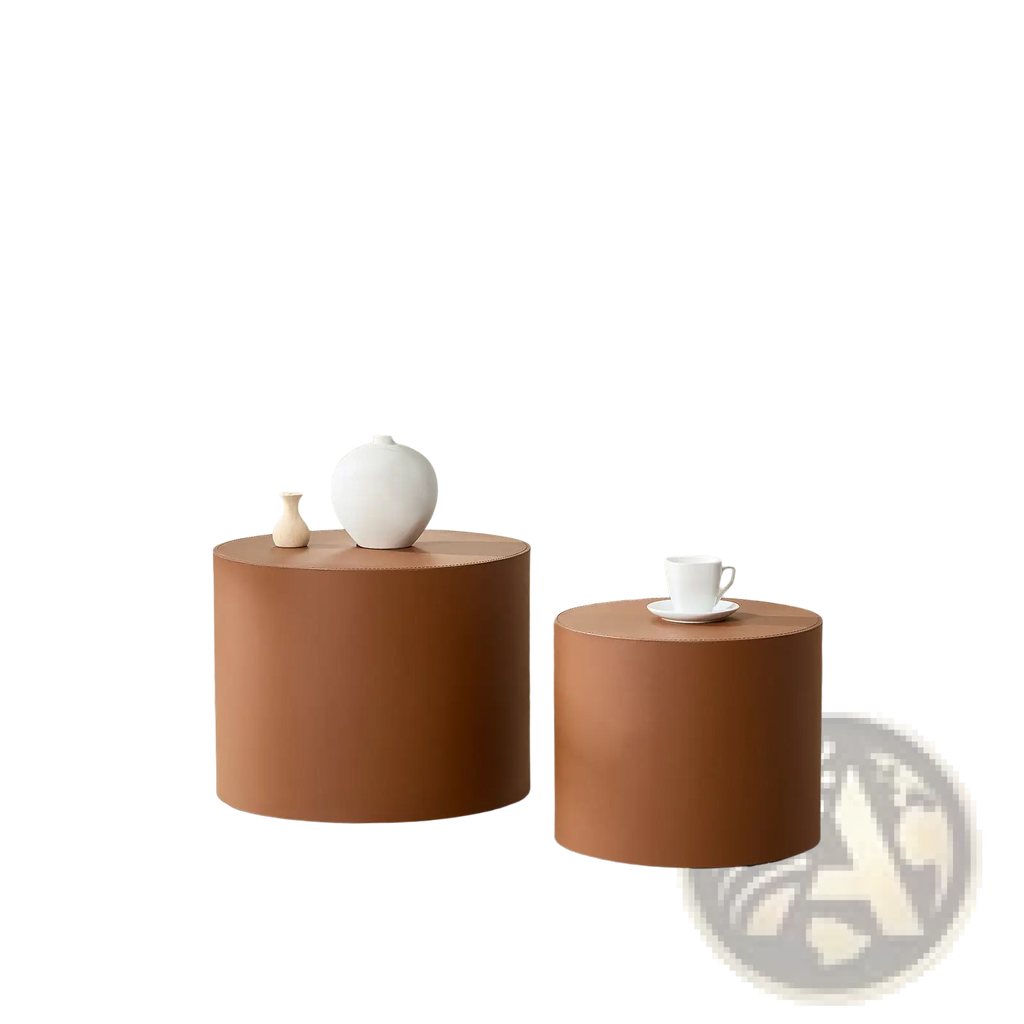 Two minimalist brown saddle leather cylindrical coffee tables in terracotta finish with one slightly larger than the other