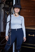 Black equestrian helmet with adjustable chin strap shown from the back paired with btr active women’s seamless upf 30 baselayer