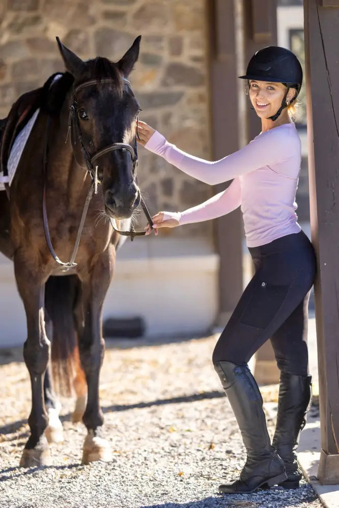 Black riding helmet with small logo front detail paired with Btr Active women’s seamless UPF 30 sun protection baselayer