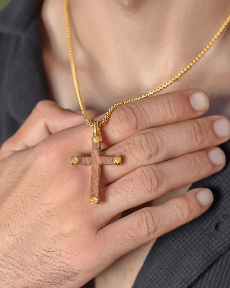 Gold-toned bubinga wood and stainless steel cross necklace with wooden center and metallic studs on matching chain