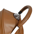 Brown leather bugaboo bee stroller handle cover with black clip and silver reflective panel visible from the back side