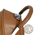 Brown leather bugaboo bee stroller handle cover with black clip and silver reflective panel visible from the back side