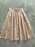 Bugs print cotton pleated doris skirt with pockets featuring a soft pink floral design and delicate leaf patterns
