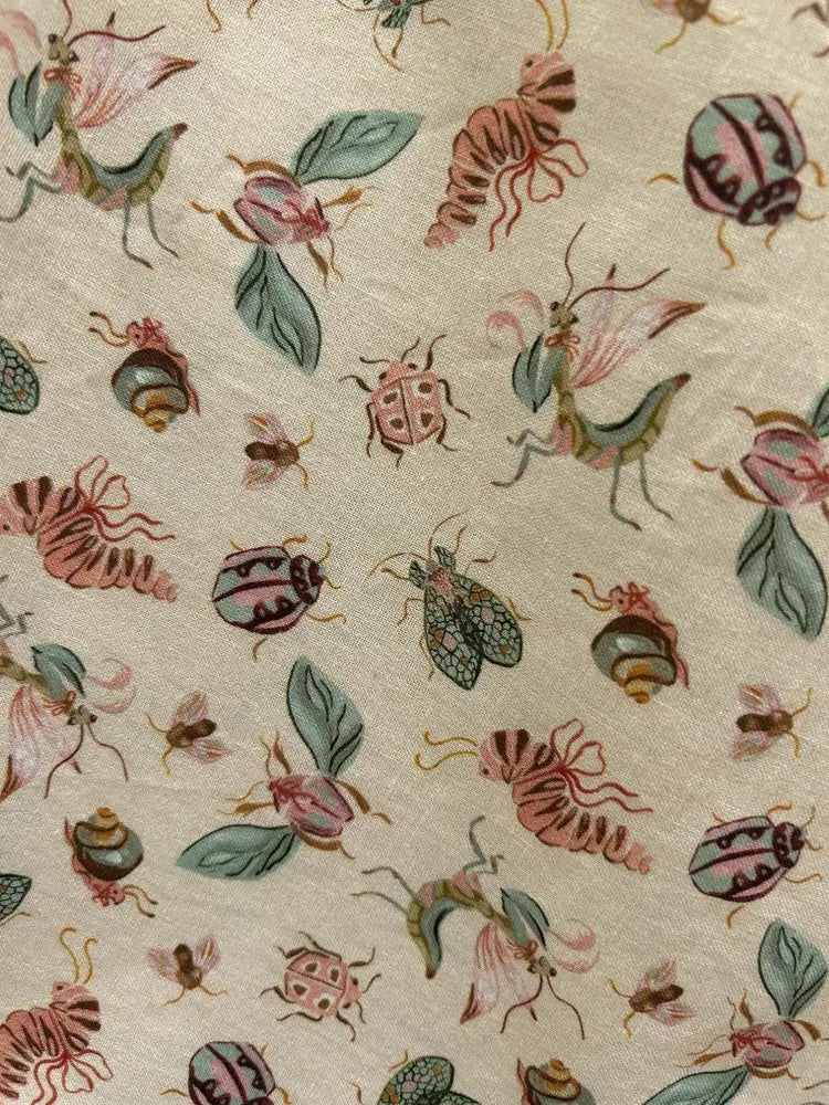 Beige cotton bugs print pleated doris skirt with pockets featuring pink green and brown illustrated insects pattern