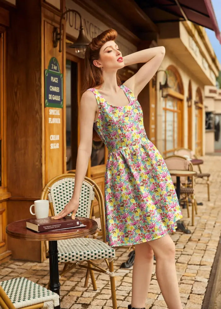 A vibrant sleeveless bunnies and floral print cotton fit and flare dress in yellow pink and green shades