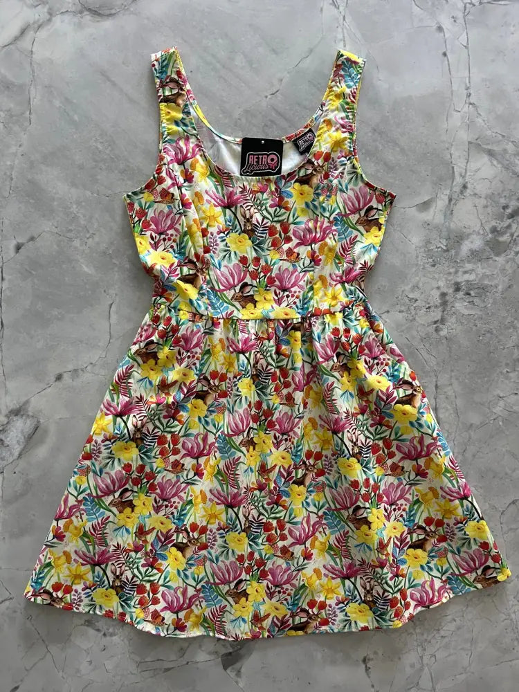 A vibrant cotton fit and flare dress with sleeveless floral print in pink yellow red and green on a light background