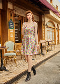 A woman wearing a sleeveless knee-length cotton fit and flare dress with a bunnies and vibrant floral print