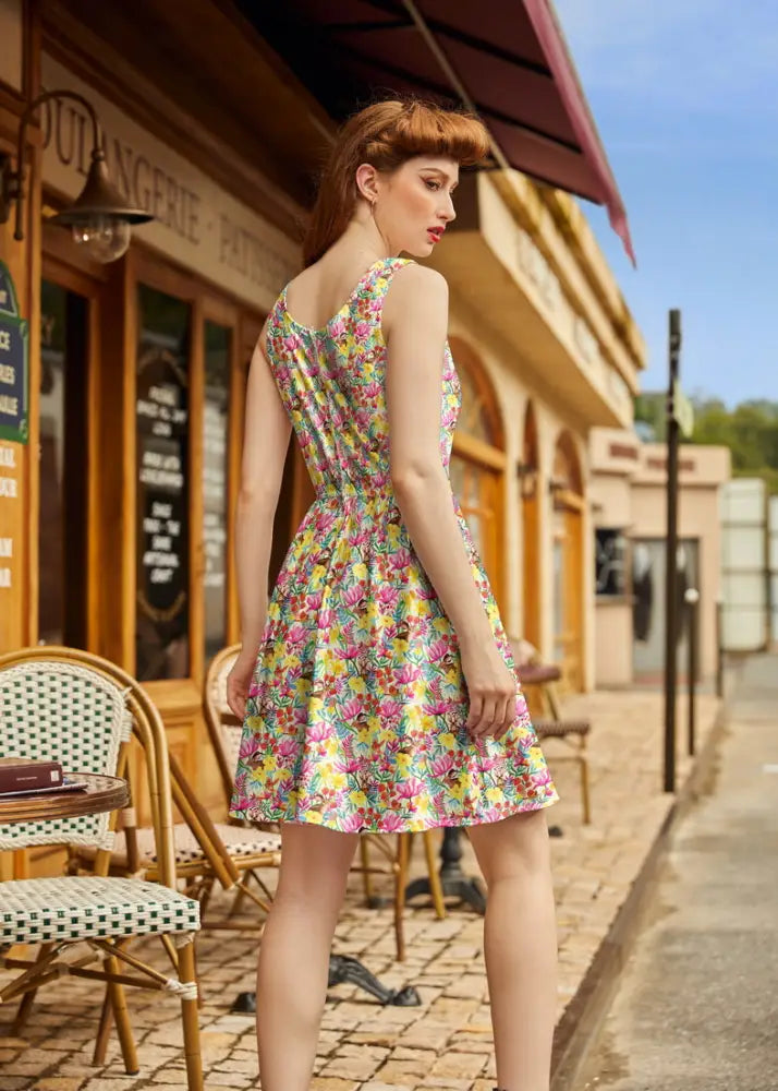 A vibrant bunnies and floral print cotton fit and flare dress in yellow pink and green with sleeveless fitted bodice