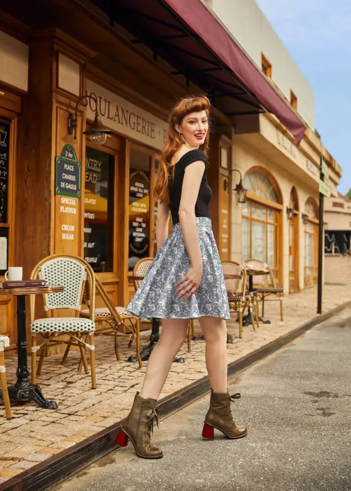 A woman wearing a vintage bunny floral cotton skater skirt in light blue paired with brown lace-up ankle boots with red heels