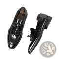 Black crocodile embossed leather tassel loafers with a glossy finish and low block heel for formal wear