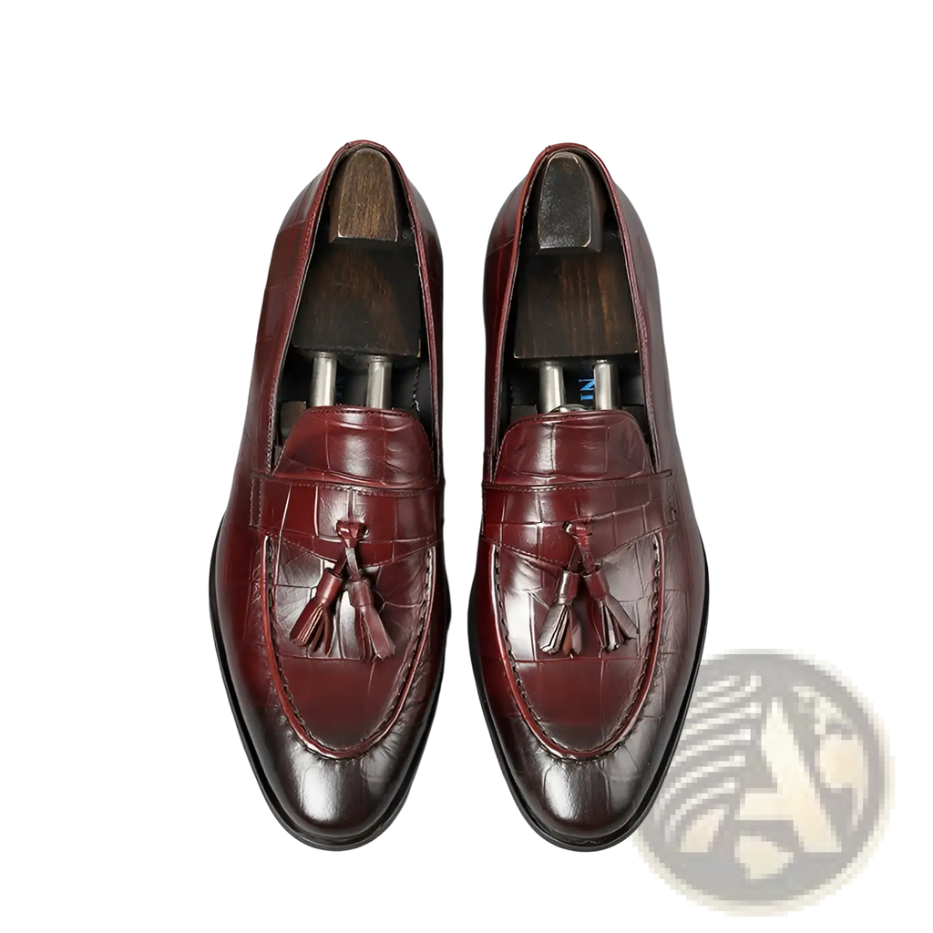 Burgundy crocodile embossed leather tassel loafers with polished finish and detailed stitching for formal wear