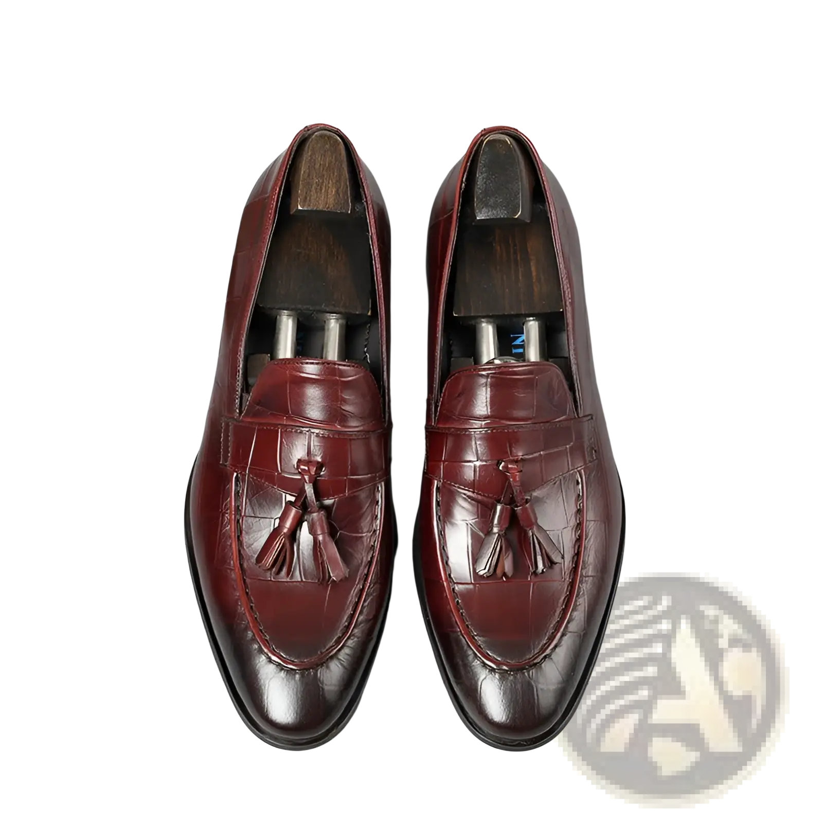 Burgundy crocodile embossed leather tassel loafers with polished finish and detailed stitching for formal wear