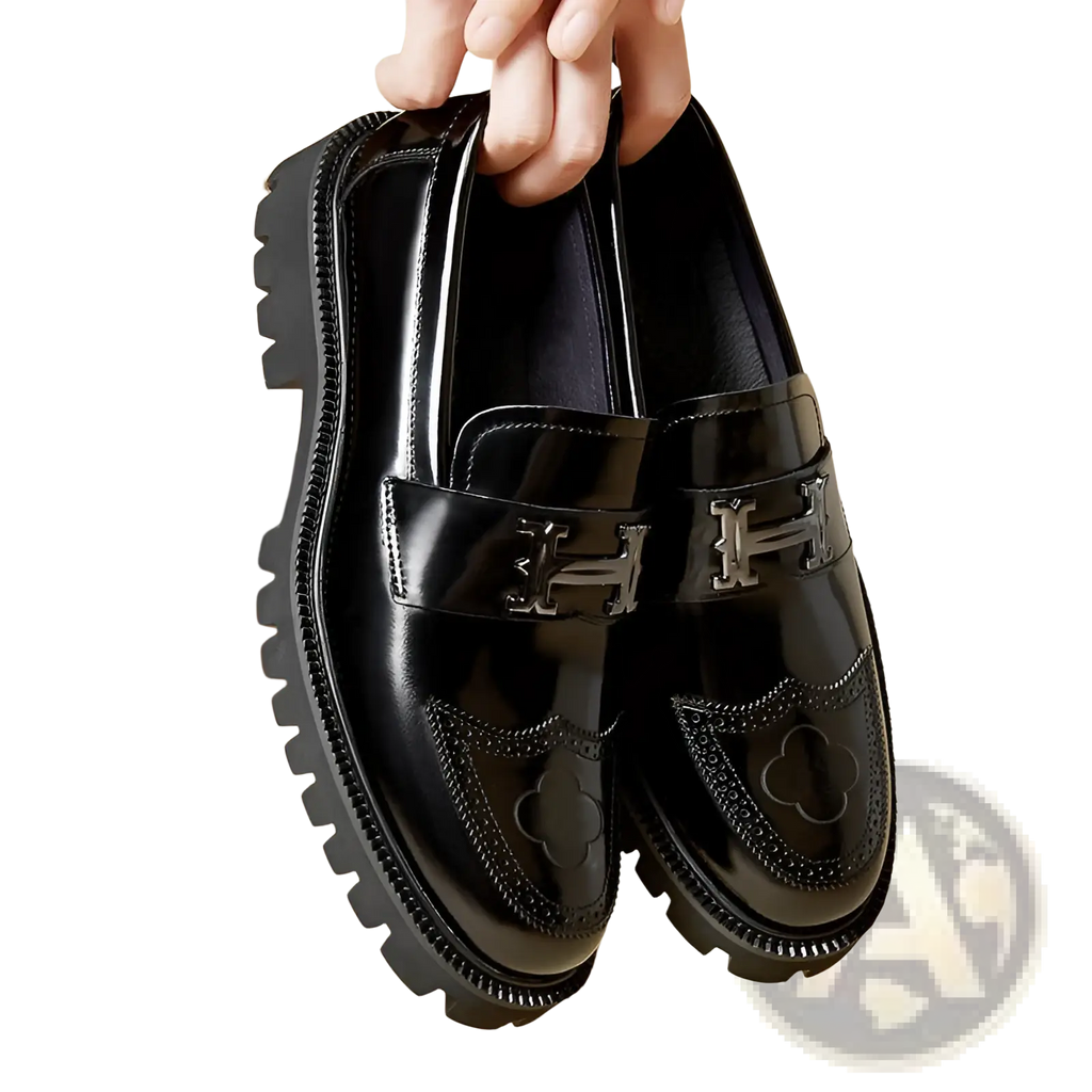 Black patent leather loafers with silver-tone h-shaped buckles and clover embroidery on the toe with rubber sole