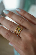 Burst adjustable gold ring set featuring gold-toned stacked rings adorned with colorful gemstones