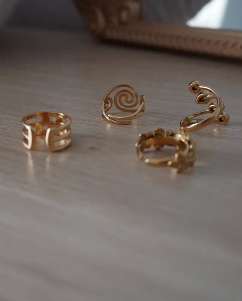 Burst adjustable gold ring set featuring gold-toned metal rings with geometric, spiral, and ornate scrollwork designs