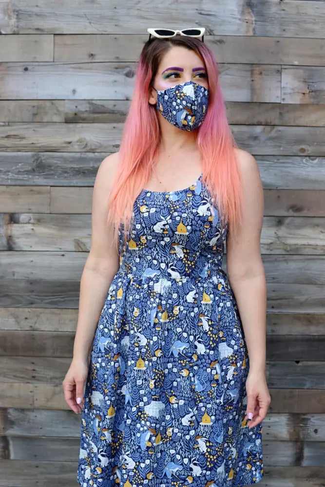 Reversible busy bee and blue gingham cotton face mask featuring a blue dress pattern with white and yellow animals