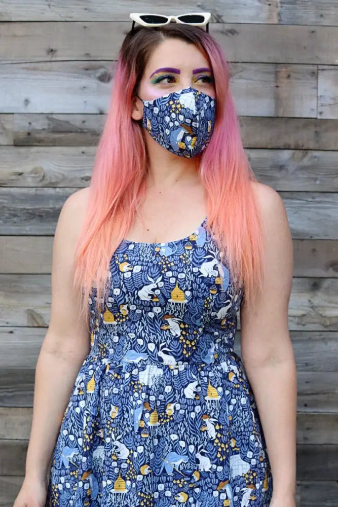 Reversible busy bee and blue gingham cotton face mask with a blue patterned side featuring whimsical animal and nature motifs