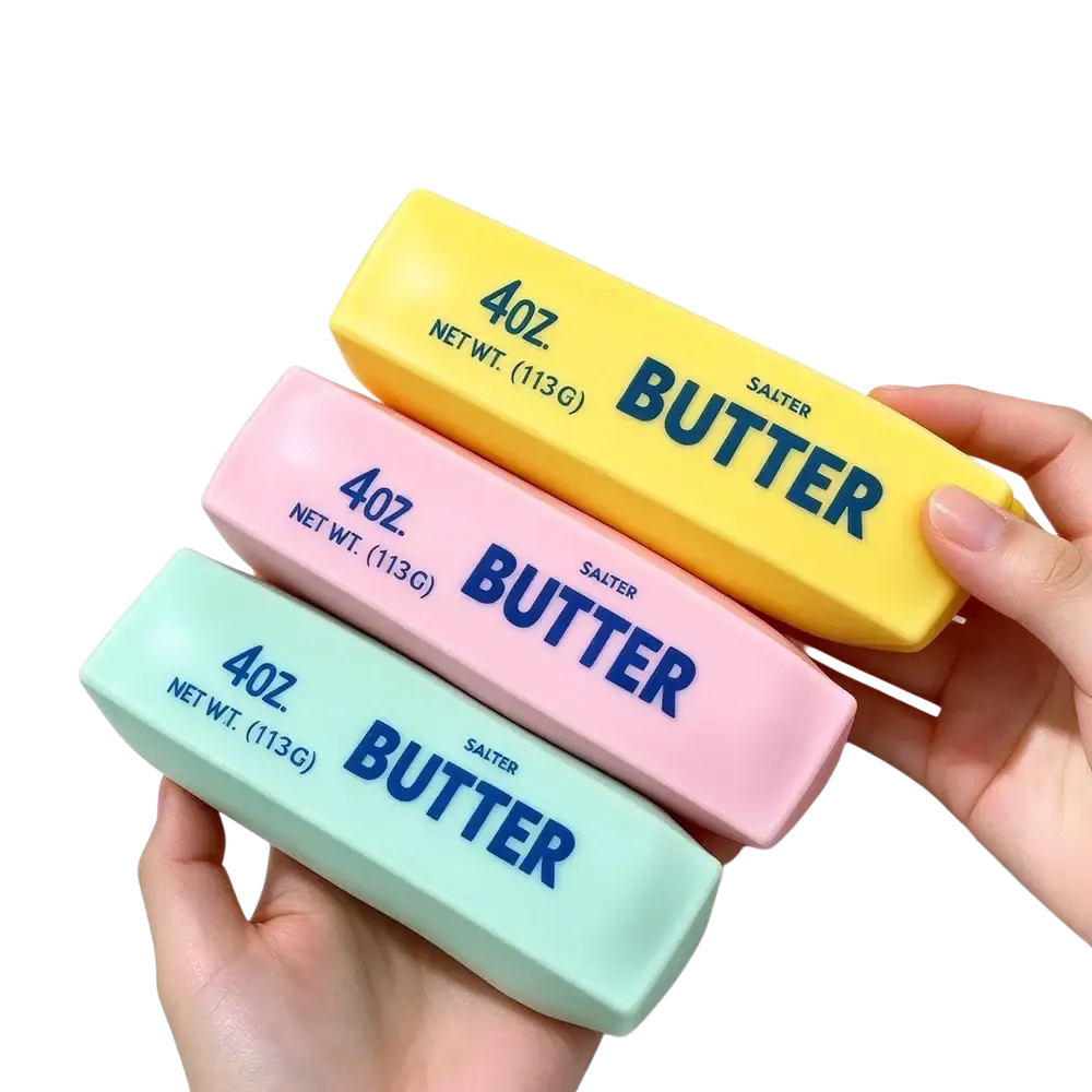 Pastel-colored squishy butter bar sensory fidget toy with butter printed in blue on a soft squeezable surface