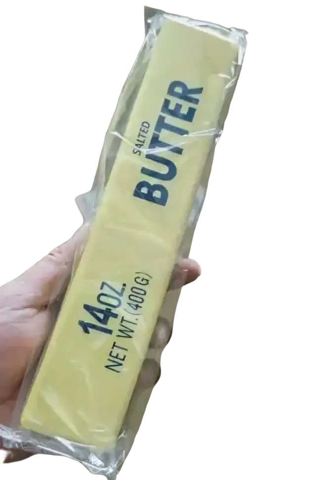 A yellow butter slow rising squishy fidget toy packaged in clear plastic labeled 14oz net wt 400g