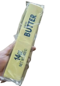 A yellow butter slow rising squishy fidget toy packaged in clear plastic labeled 14oz net wt 400g