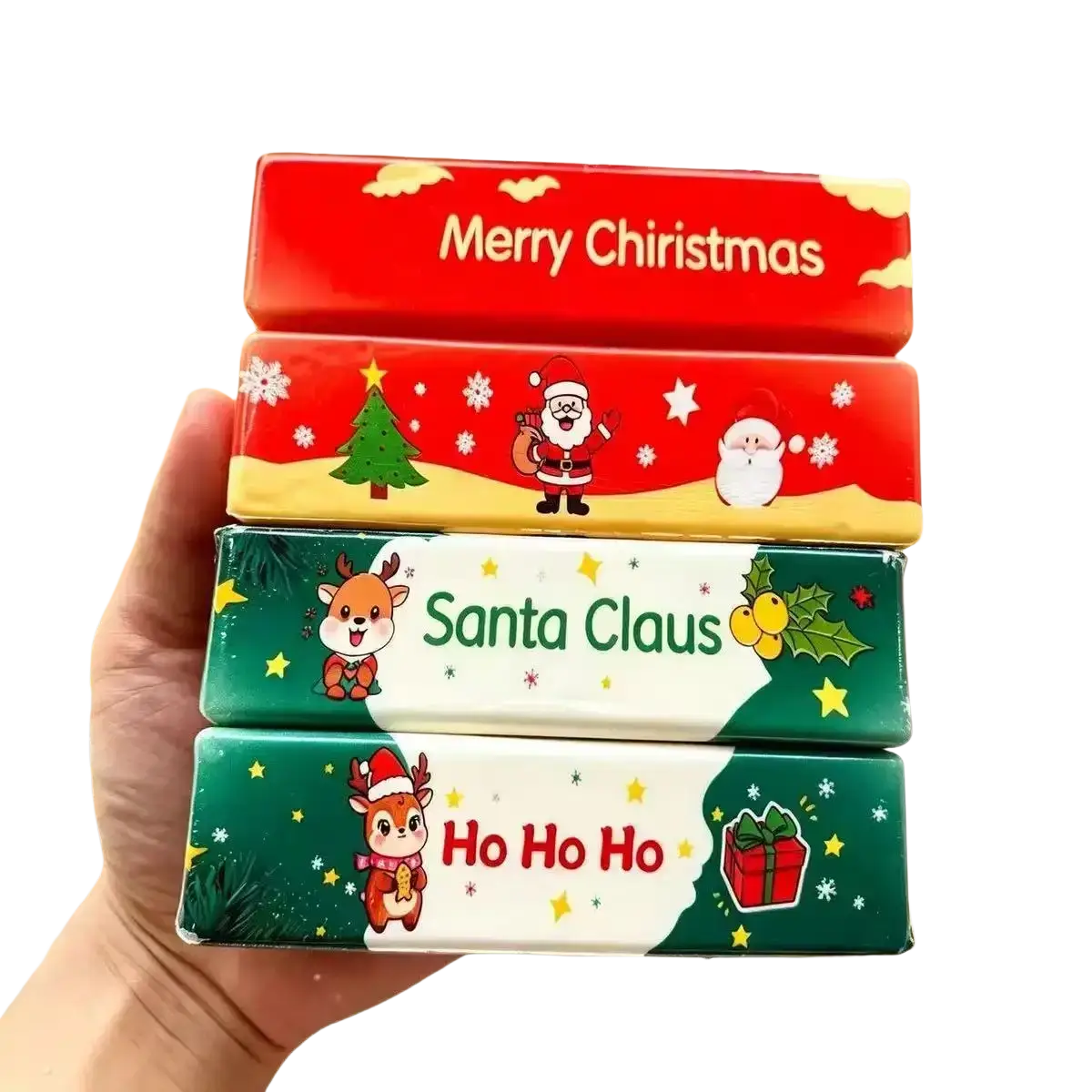 A hand holding four festive butter squishy toy slow rising tissue boxes with christmas-themed santa and reindeer designs