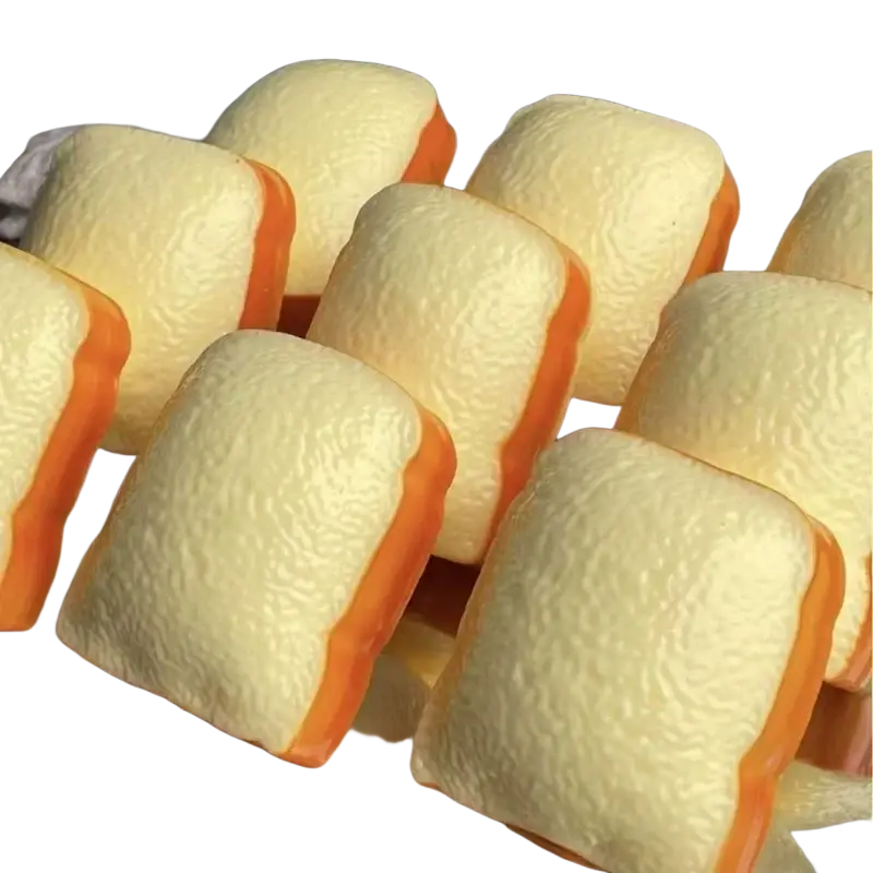 Plump pale yellow and orange silicone bread-shaped bath bombs with textured surface from butter stick asmr sensory squishy toy