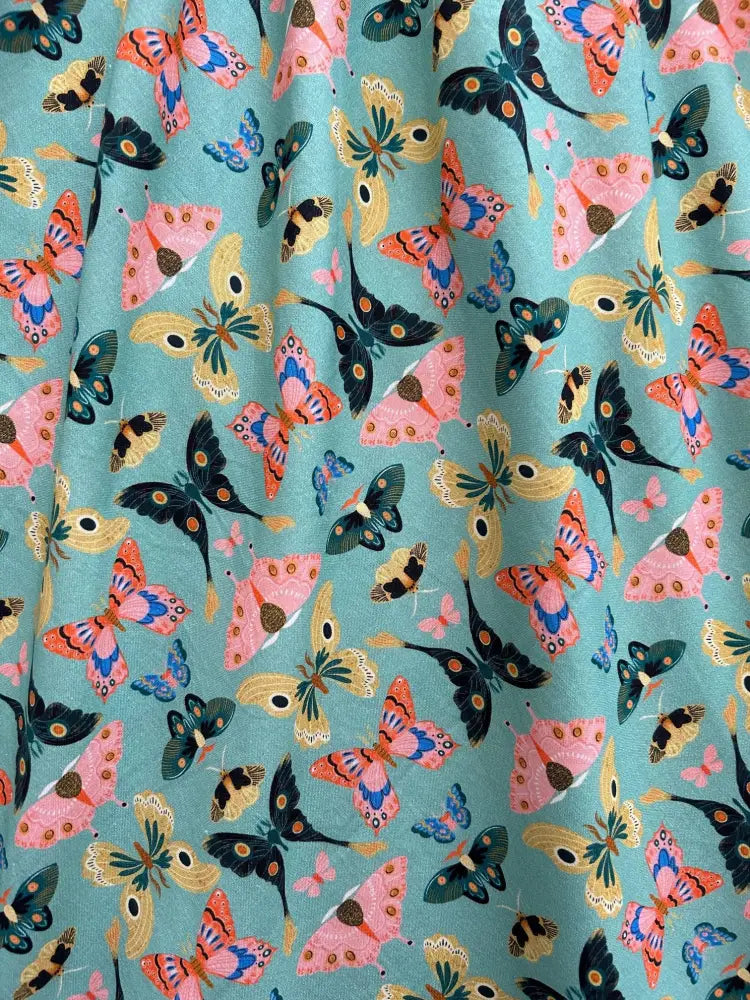 Vintage 1950s mint butterfly print cotton midi dress featuring vibrant turquoise fabric with multicolored butterfly pattern