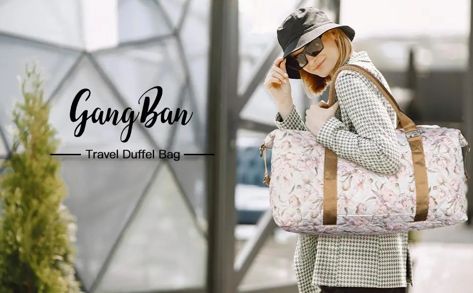 un sac de voyage duffel pour femme à motif floral rose, avec des sangles en cuir brun et une trousse de toilette.