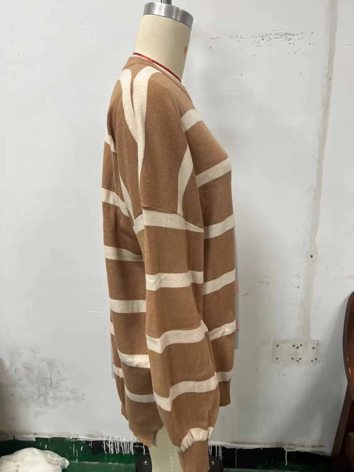 A cozy women’s oversized split color striped knit sweater featuring warm brown and cream horizontal stripes.