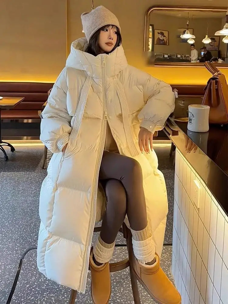 Cream-colored women long padded down jacket quilted coat featuring a hood and ribbed side panels.