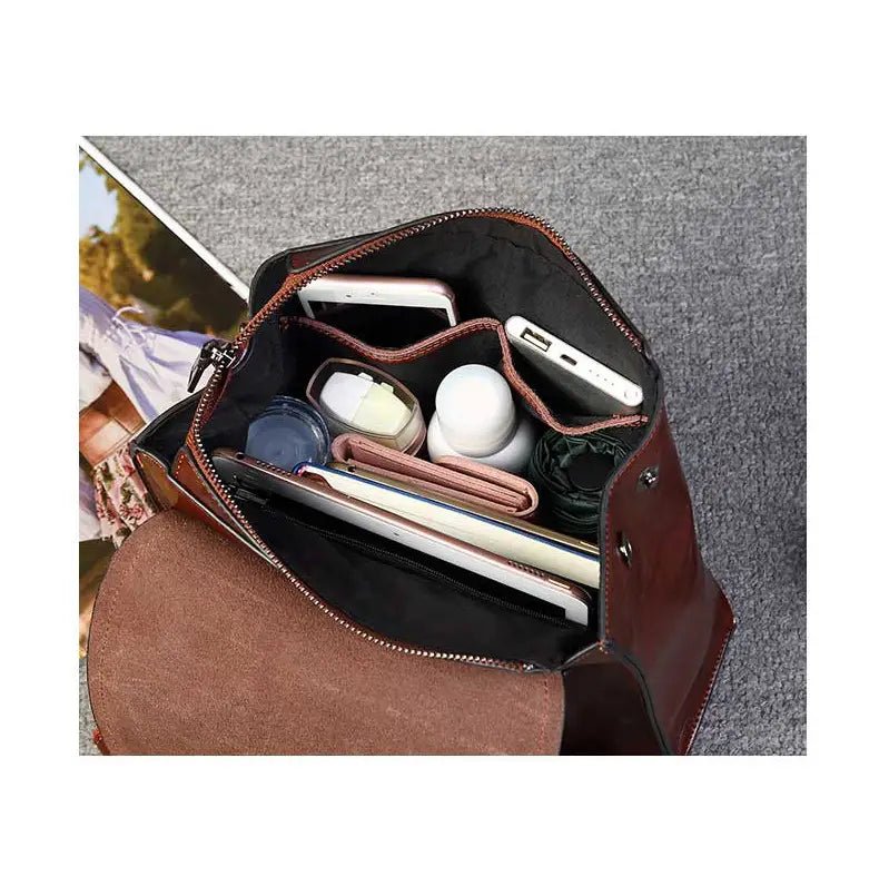 Bolso cruzado de cuero marrón con varios compartimentos y cierre con cremallera, incluido en una mochila bandolera de cuero estilo moda retro.