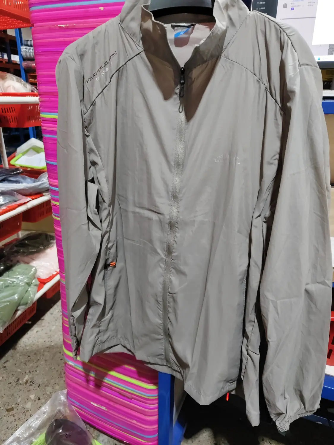 Men’s ultrathin sun protective sports jacket in gray lightweight material with a full-length zipper and subtle branding on the collar.