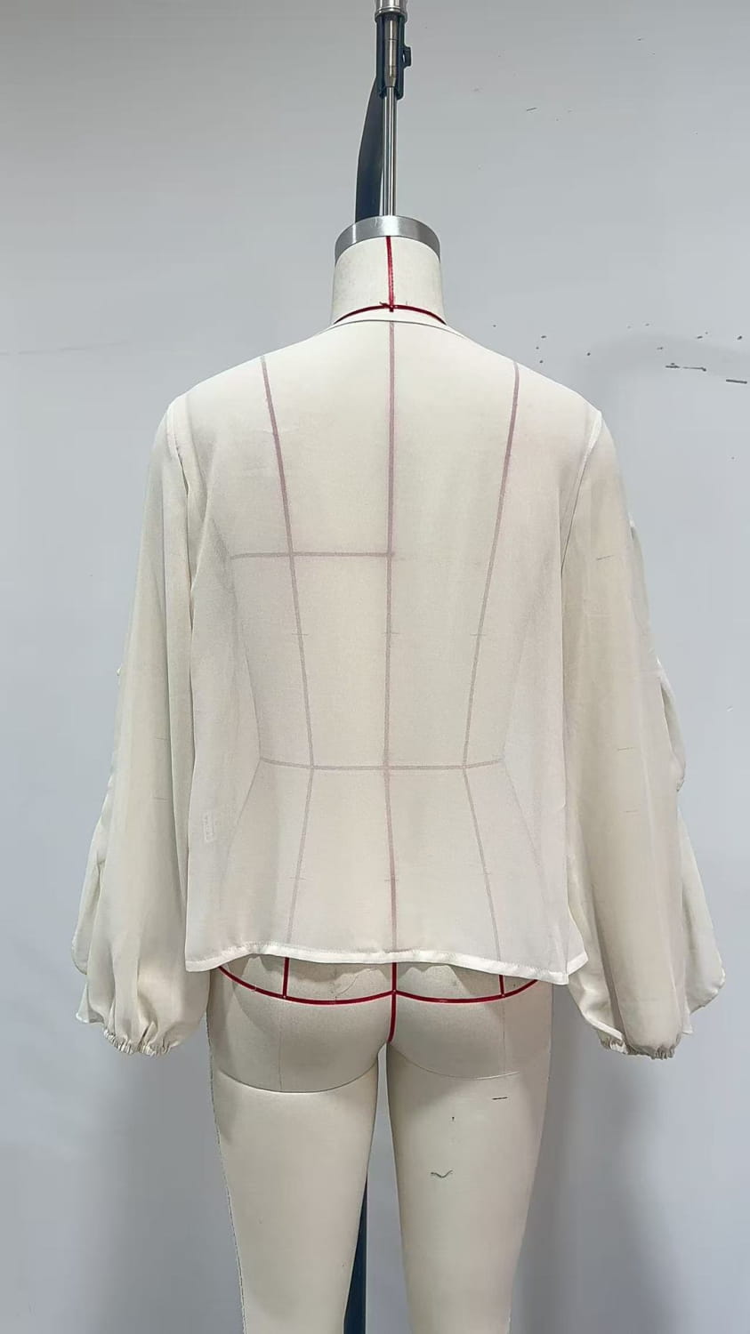 Eine beigefarbene, geraffte Chiffonbluse mit langen Ärmeln und figurbetonter Taille, entworfen als lässiges Oberteil.