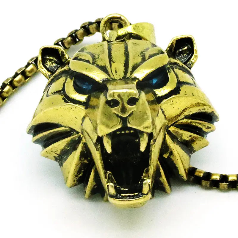 Geometric wild game animal pendant chain necklace featuring a gold-colored tiger head pendant with blue inlaid eyes and a textured fierce expression.