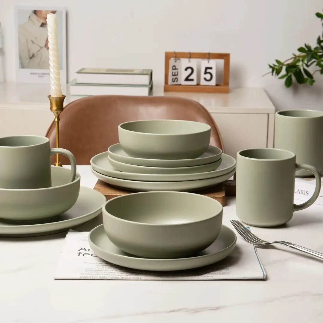 Gedämpftes salbeigrünes Steinzeug-Geschirrset mit 12 Teilen, mit minimalistischen abgerundeten Kanten und matter Oberfläche, ausgelegt für vier Personen.