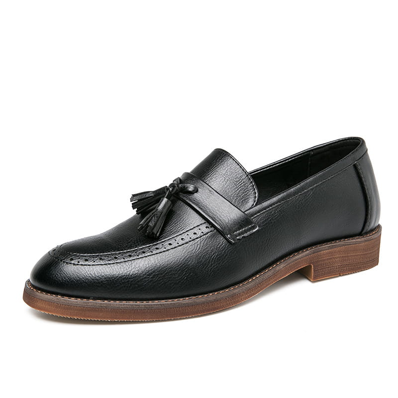 Mocasín de cuero tipo brogue con borlas para hombre en negro con suela de goma marrón y patrón brogue detallado.