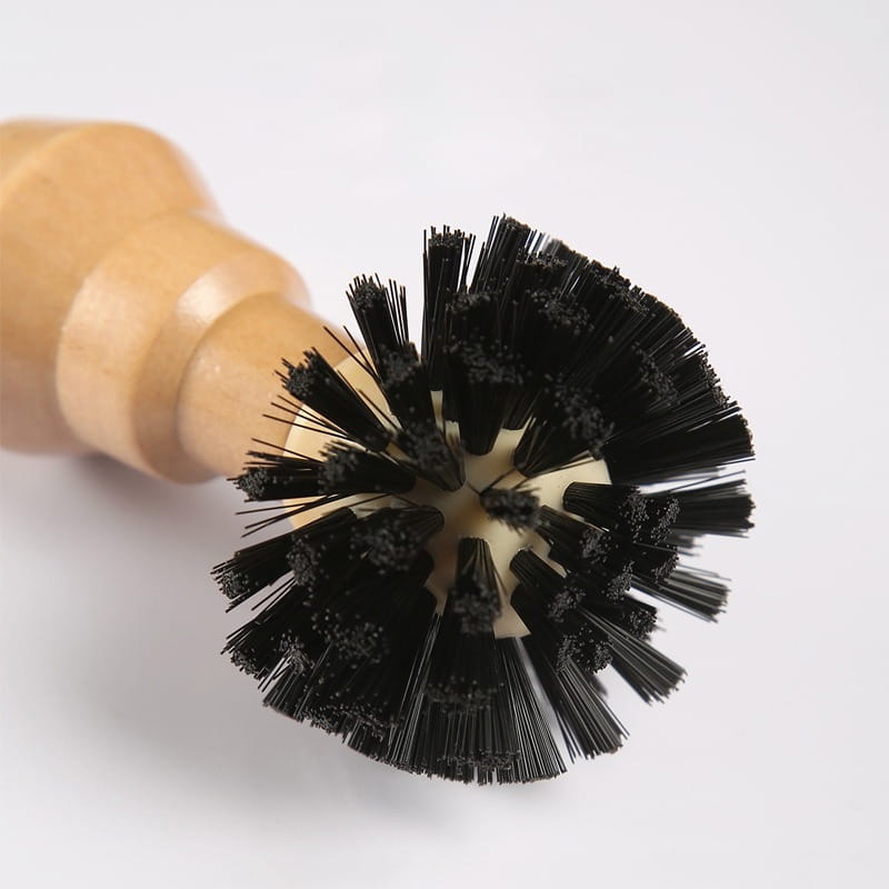 A wooden-handled coffee machine cleaning brush with dense black bristles arranged in a circular pattern from a 4 piece wood handle set.