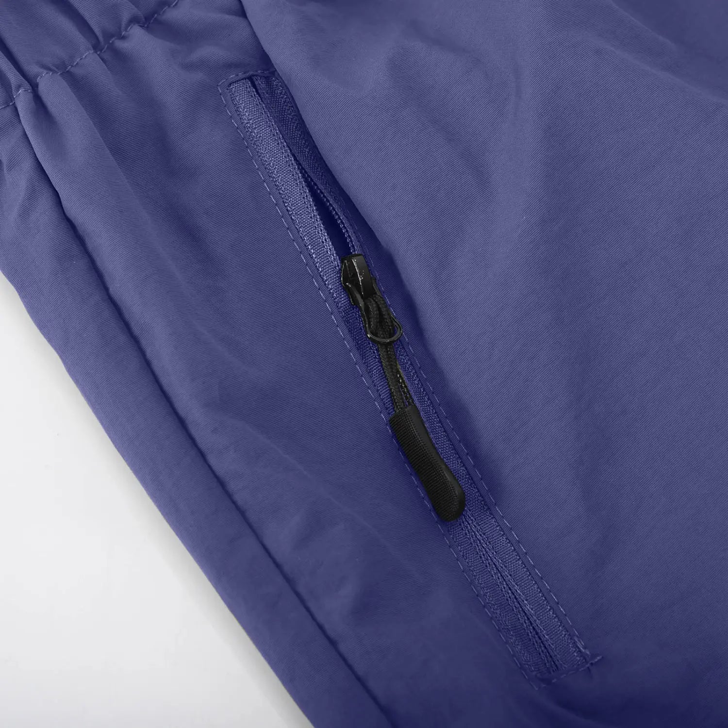 Short cargo athlétique pour hommes à jambe droite en nylon couleur violet, avec des poches à fermeture éclair noires dotées de languettes de traction.
