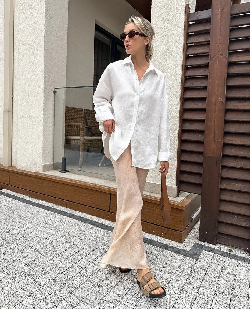 A flowing white linen women’s oversized textured button up cardigan blouse with a relaxed fit and button-down front.