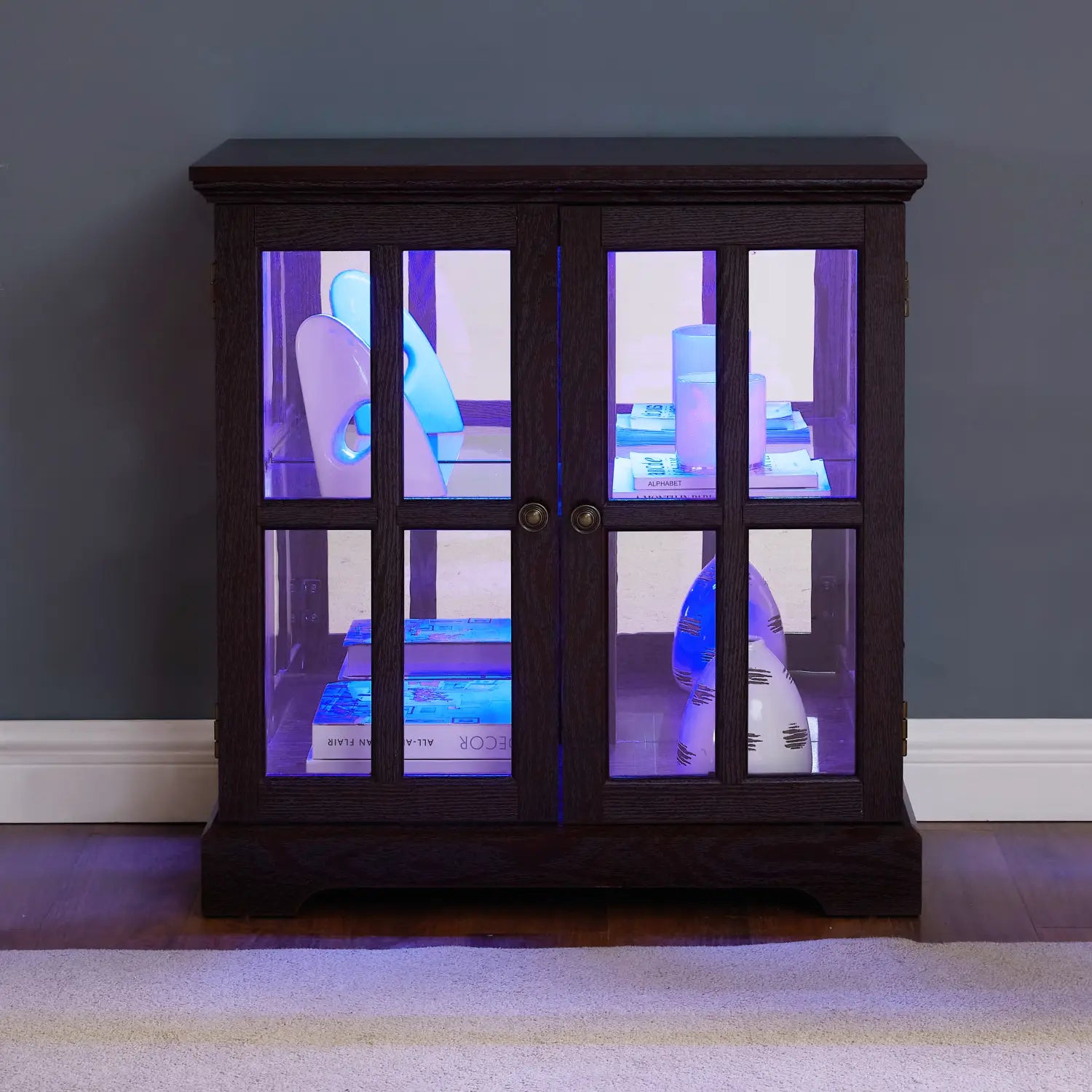 Dark wood two-door led curio display cabinet with glass panels and internal purple LED lighting featuring adjustable shelves.