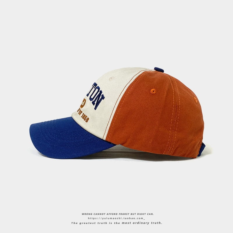 Casquette de baseball rétro à empiècements contrastés colorée en crème, orange et bleu, avec lettrage brodé, conçue comme un chapeau de soleil.