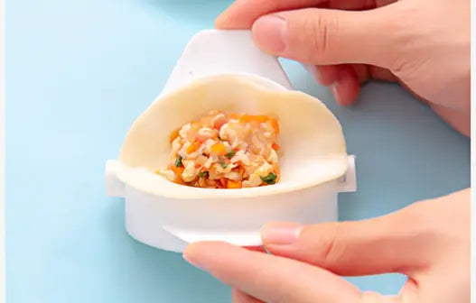 White plastic triangular dumpling maker 3 in 1 manual dough pressing tool with a small compartment holding colorful filling