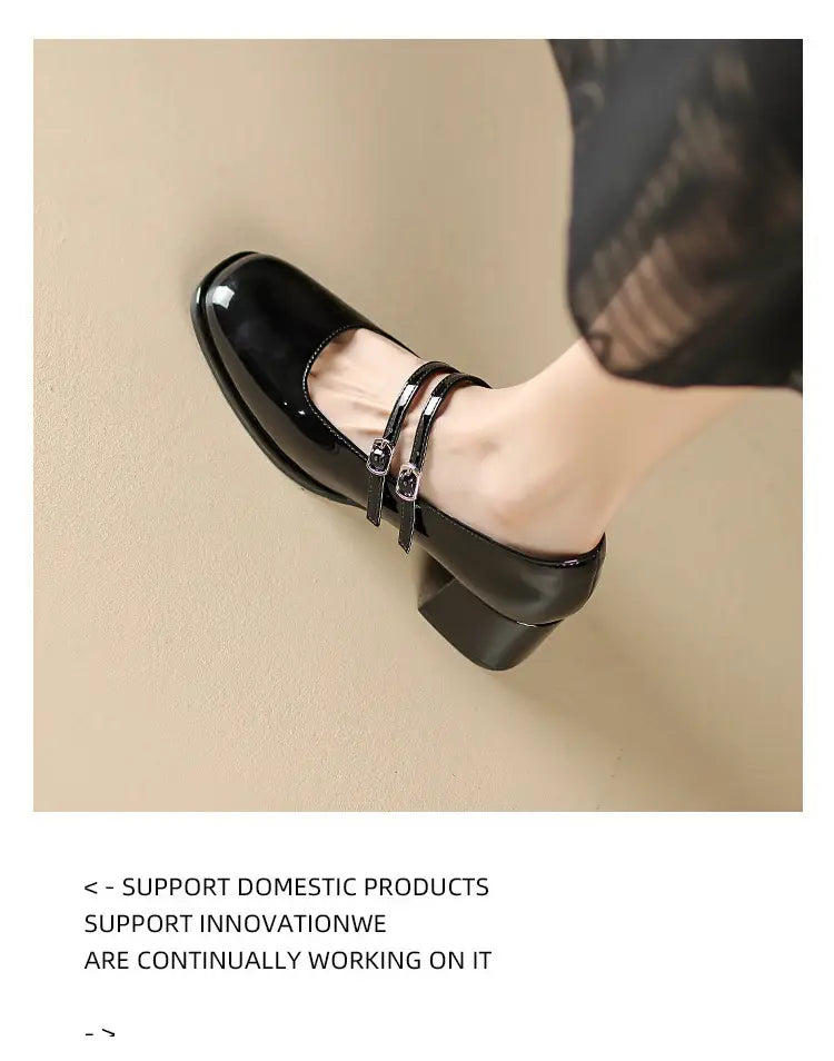 Black patent leather mary jane double strap block heel shoes with silver-toned adjustable buckles.