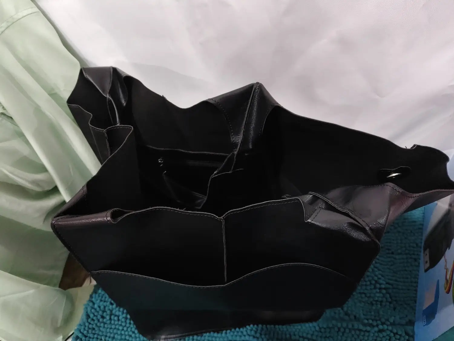Black leather tote bag with structured shape and visible stitching designed for large capacity and soft slouchy shoulder use.