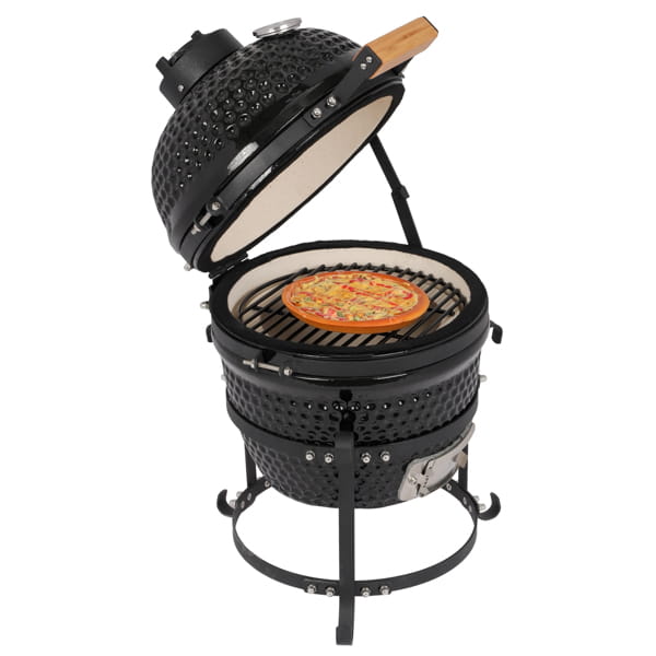 Black ceramic 13 inch kamado charcoal grill with a round pizza cooking on the grates inside.