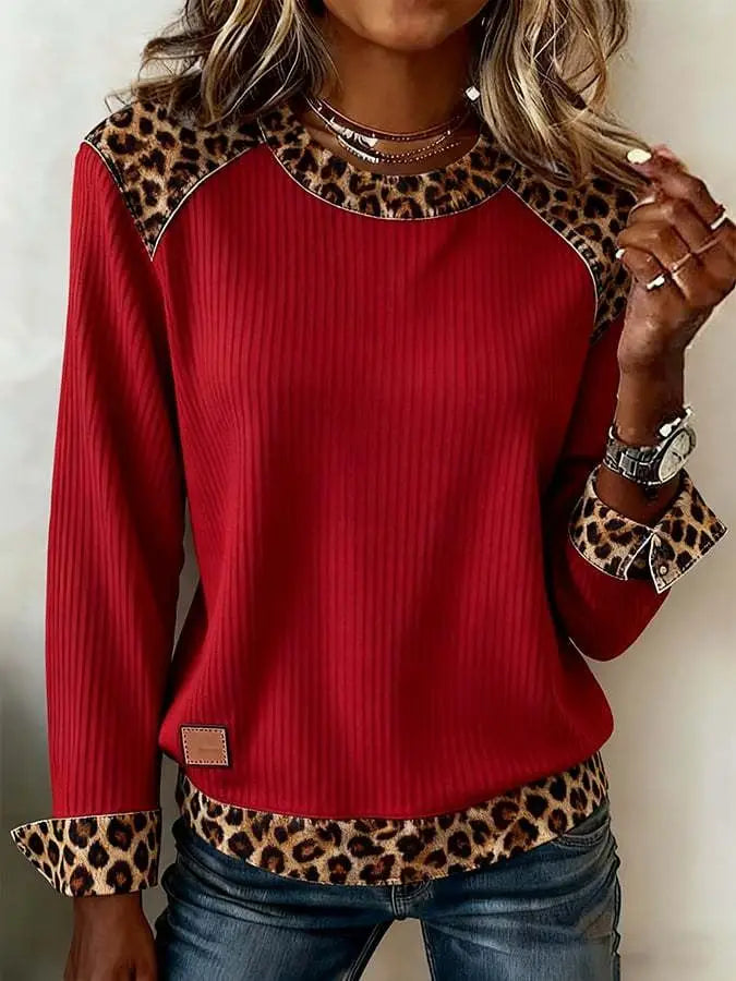 Sweat-shirt d’accent en denim à paillettes rouges comportant un design de pull côtelé rouge avec des accents à motif léopard sur les épaules, les poignets et l’ourlet.