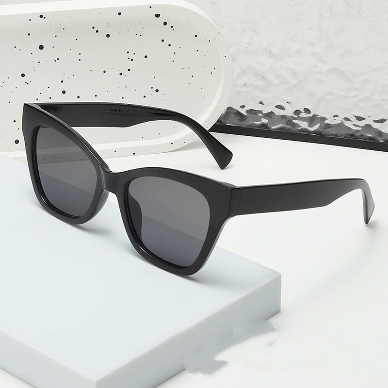Gafas de sol de moda retro con forma de ojo de gato color negro con protección UV, con lentes gris oscuro y una montura de plástico lisa y brillante.